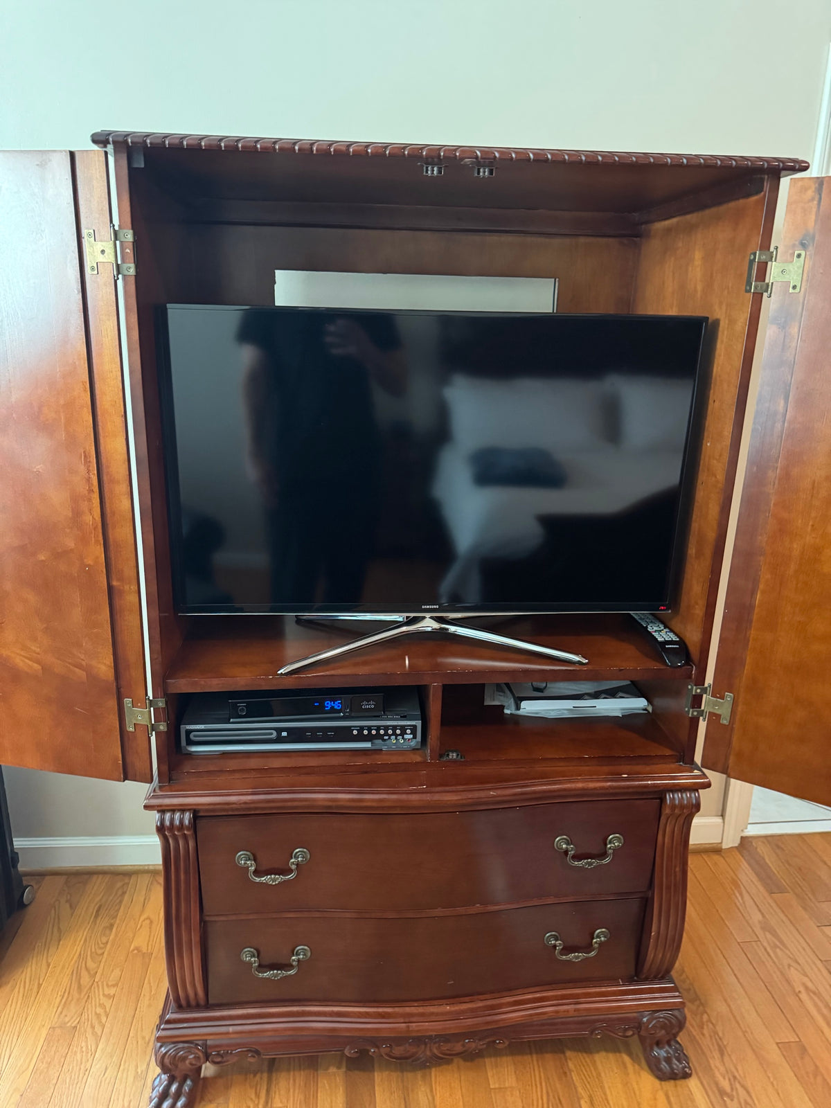 Interior of armoire showing television shelf and lower storage drawers with doors open