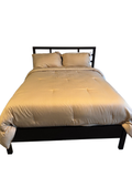 Espresso platform queen bed with slat headboard, dressed with striped tan bedding, next to a matching dark wood nightstand