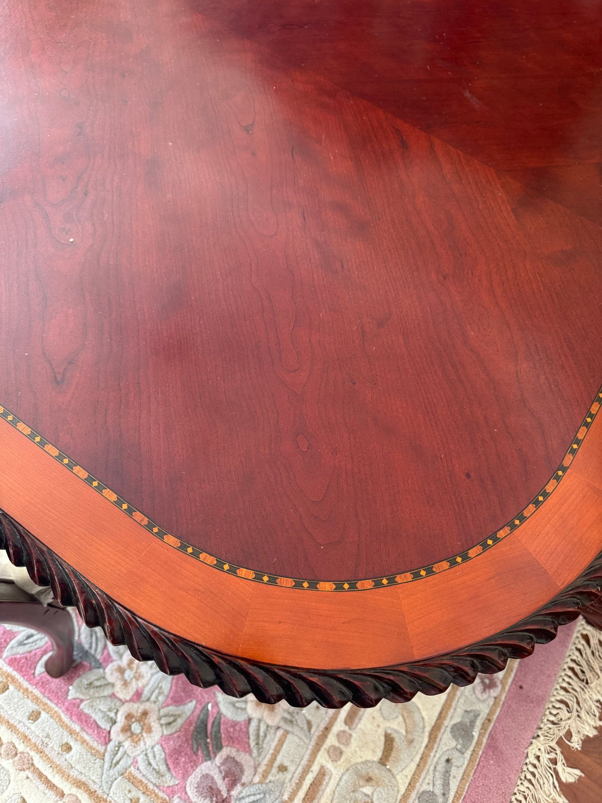 Close view of the table top showing the inlaid band and rope-carved edge