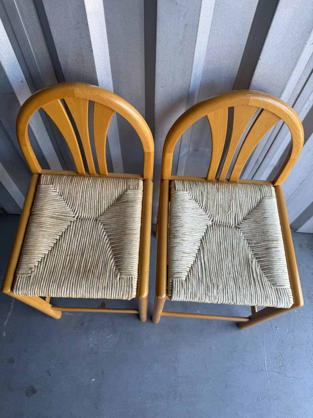 Two bar stools from above showing woven rush seat pattern and wooden frame construction