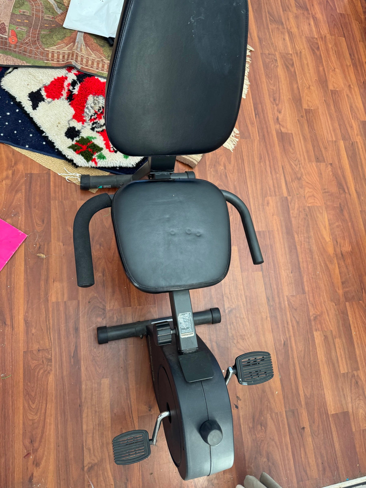 Recumbent cycle seen from the front showing seat, handgrips and pedals