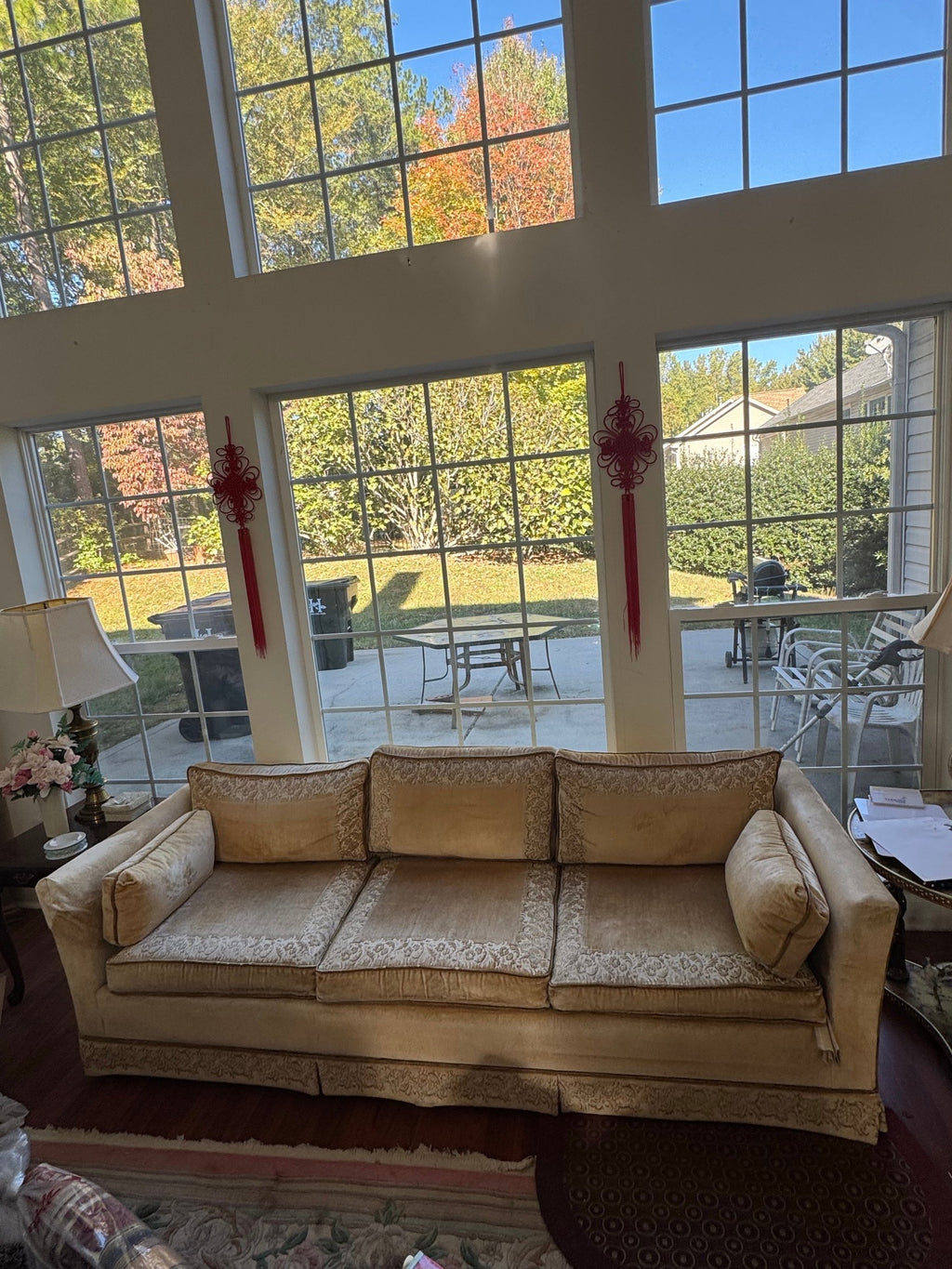 Gold velvet sofa from the front with bolster pillows at both ends