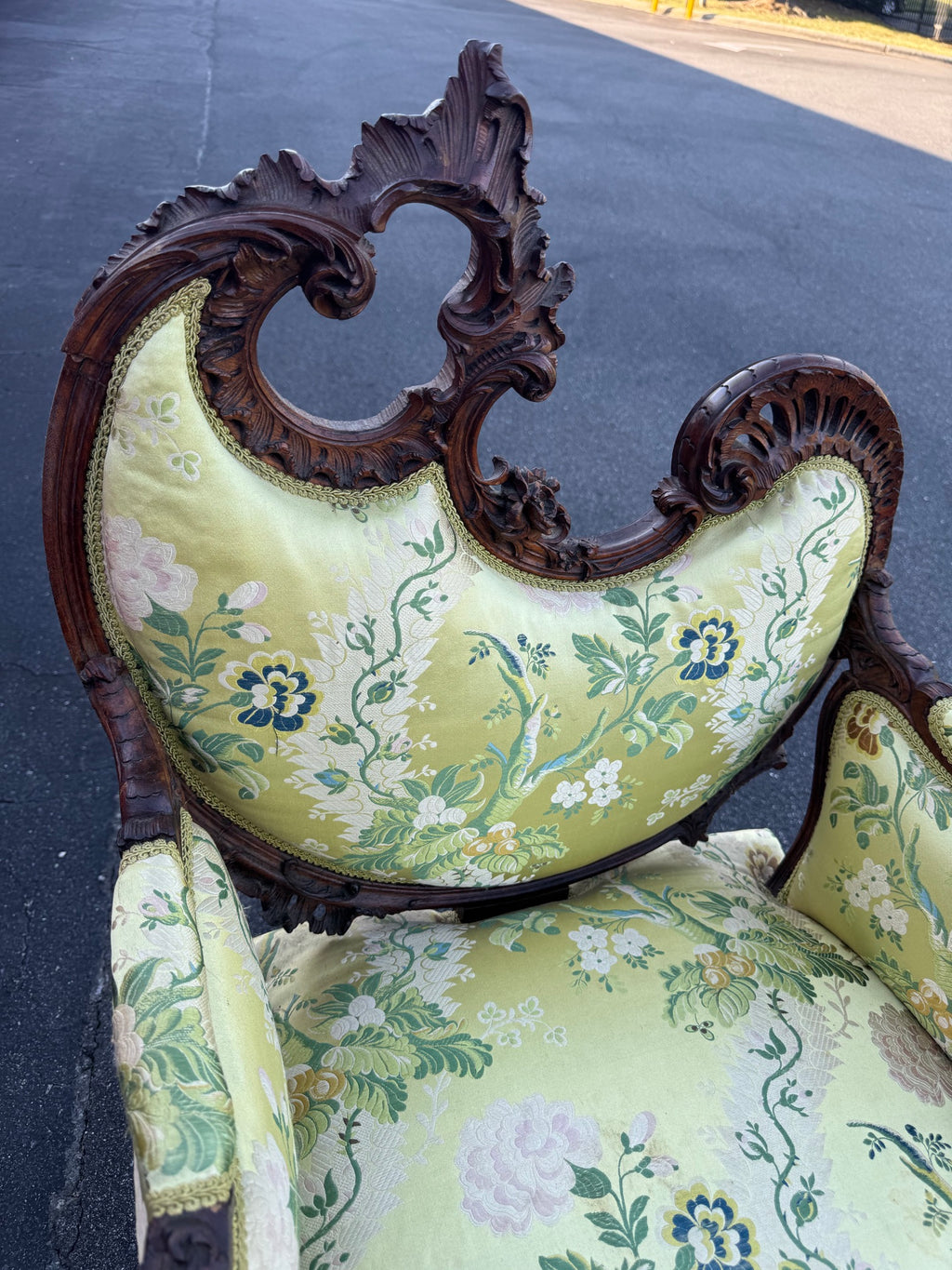 The pierced crest rail from above, showing the depth of the undercut carving and the gadrooned right shoulder