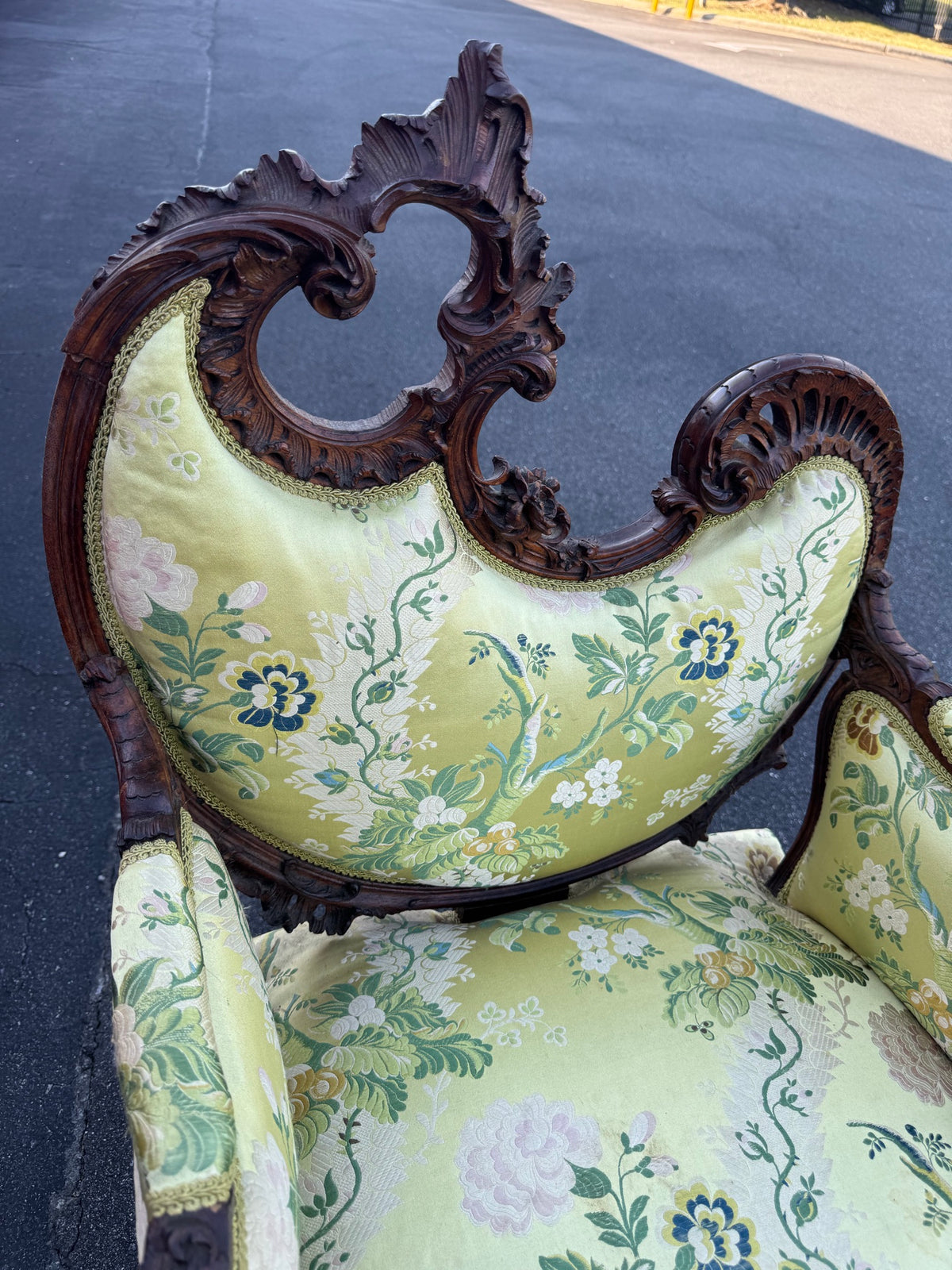 The pierced crest rail from above, showing the depth of the undercut carving and the gadrooned right shoulder