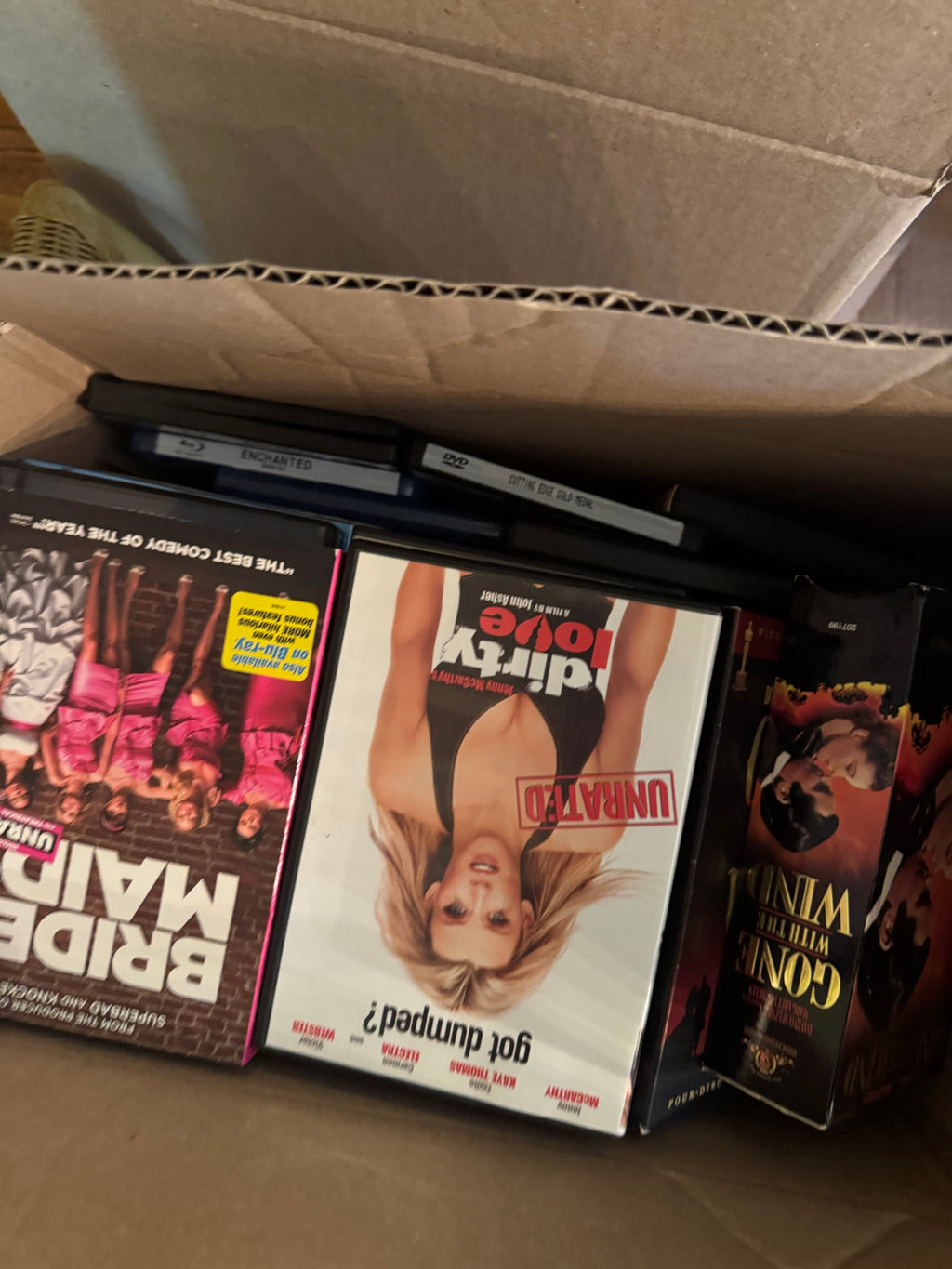 Three DVD/Blu-ray cases arranged in black case holders, titles partially visible with upside-down text, close-up of collection contents