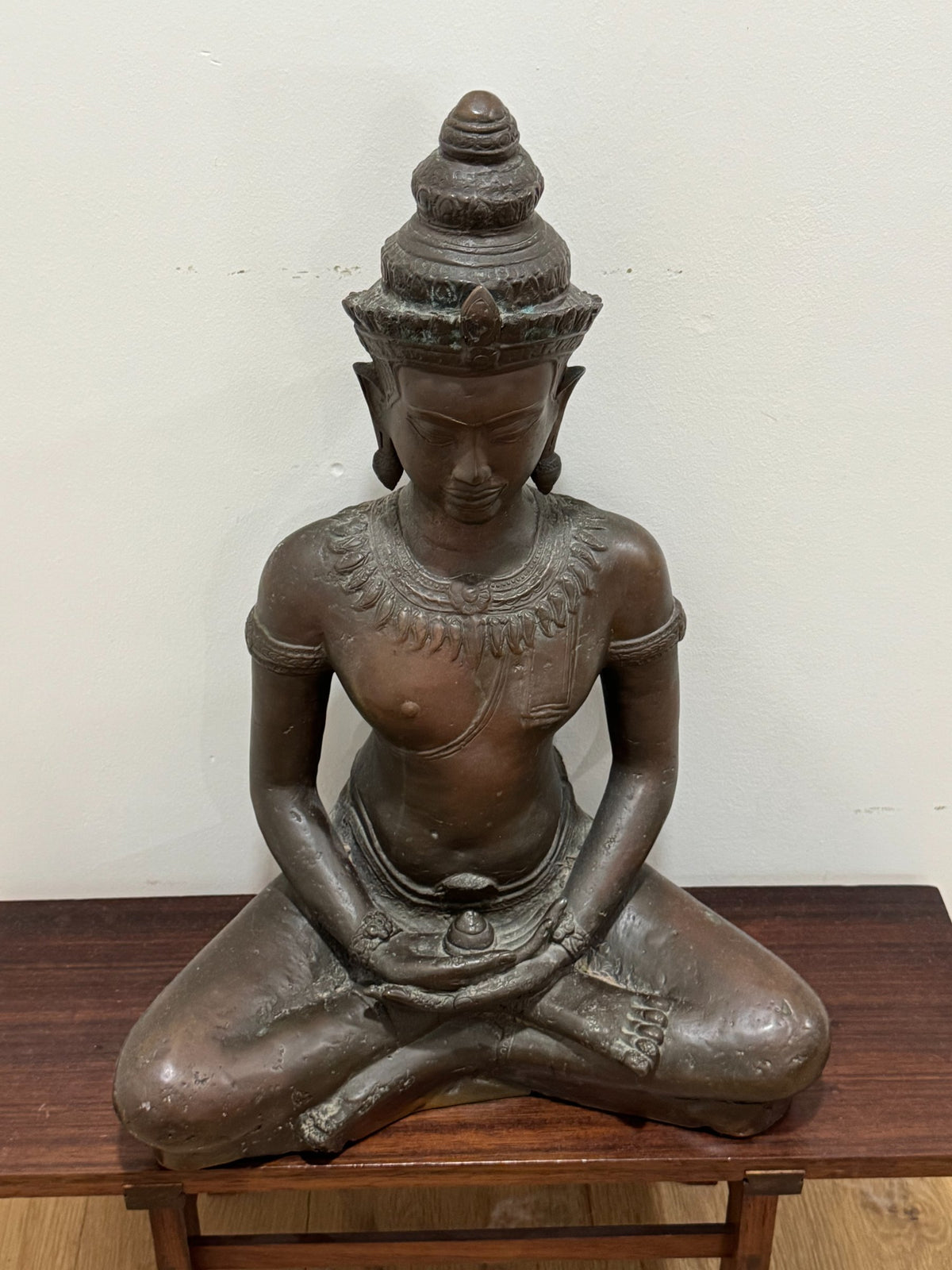Buddha bust detail showing face, crown, and ornamental necklace with careful carving work