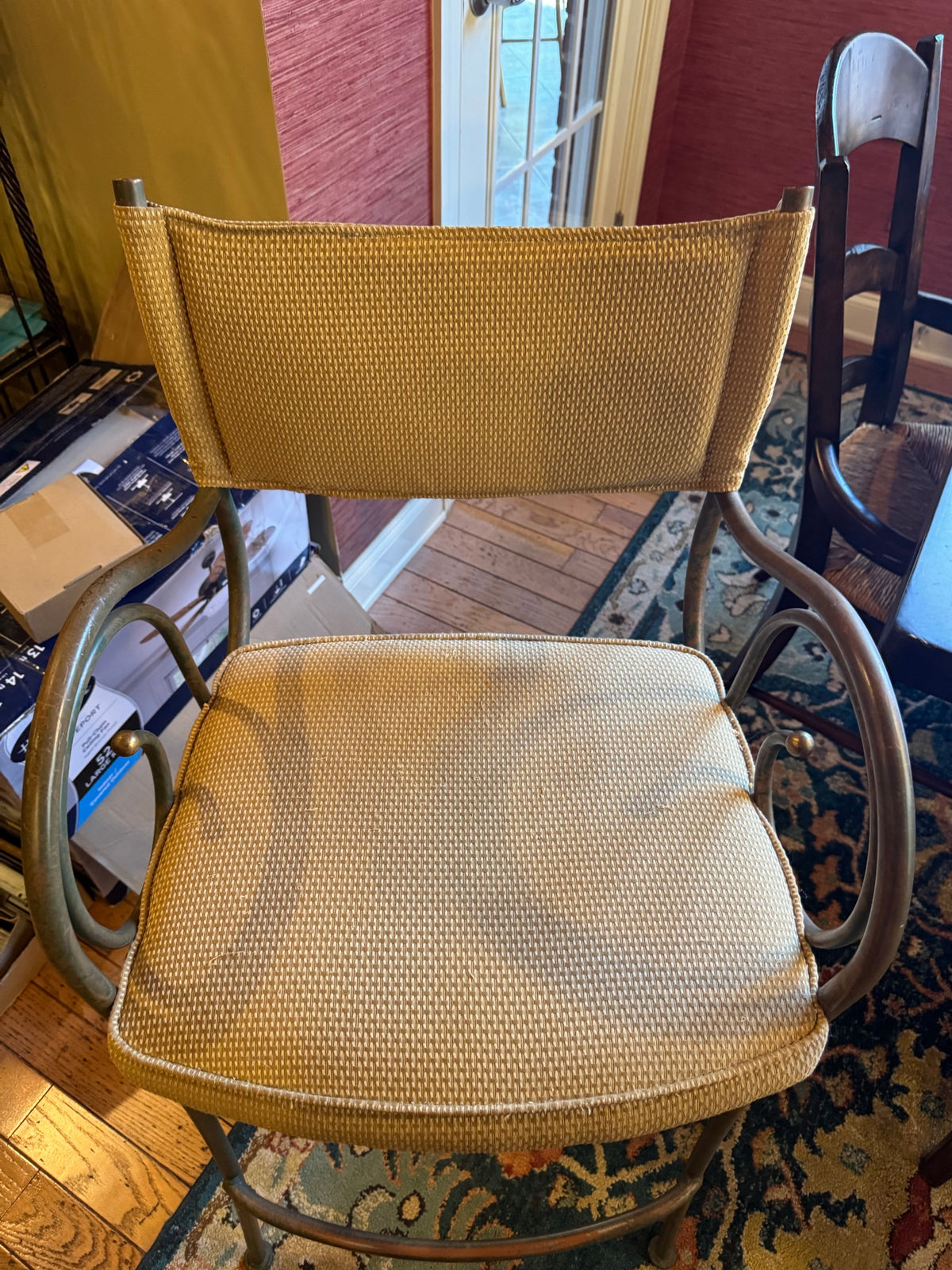 Gold upholstered bar stool with curved metal frame and footrest, back view showing upholstery detail