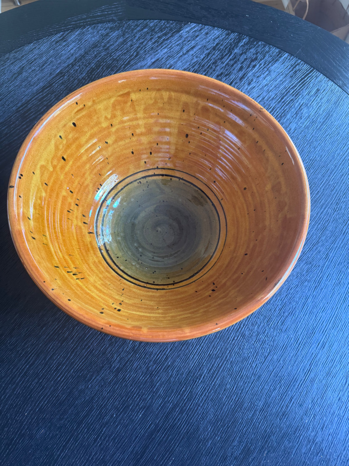 Top-down view of bowl interior displaying concentric rings from wheel-thrown construction, with dark center and speckled surface