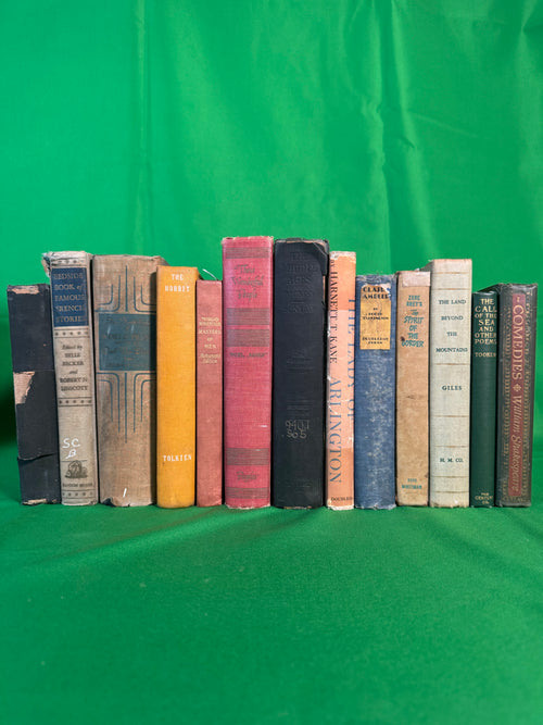 Vintage hardcovers stood spine-out on green cloth, including The Hobbit by J. R. R. Tolkien, Masters of Men from Morgan Robertson's Autograph Edition, and Zane Grey's The Spirit of the Border