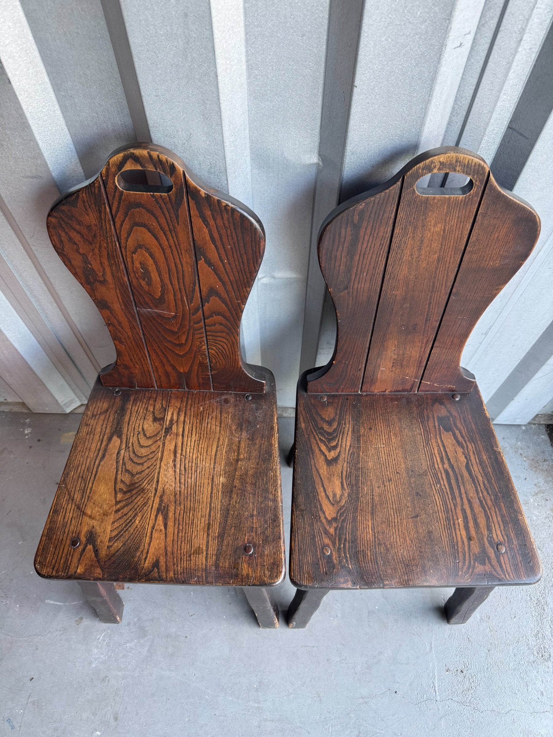Two chairs from above showing seat surfaces with wood grain and metal fasteners