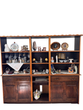Dark wood wall unit with open shelves above and cabinets below, filled with decor