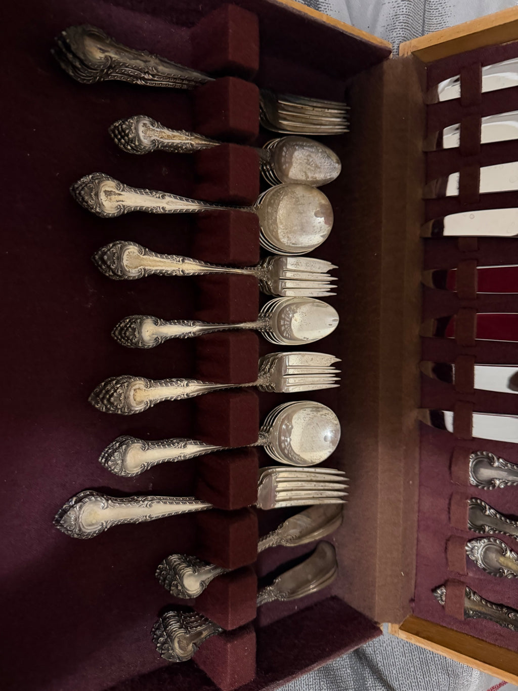 Lower drawer contents from different angle showing organized arrangement of forks, spoons, and serving utensils with decorative silver handles