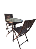 Round glass-top bistro table with two espresso wicker folding chairs in a sunroom