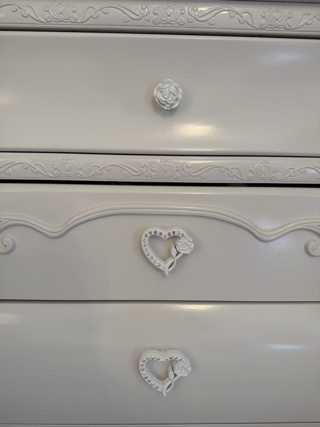 Heart and rose pulls and scroll appliqués on the chest drawers
