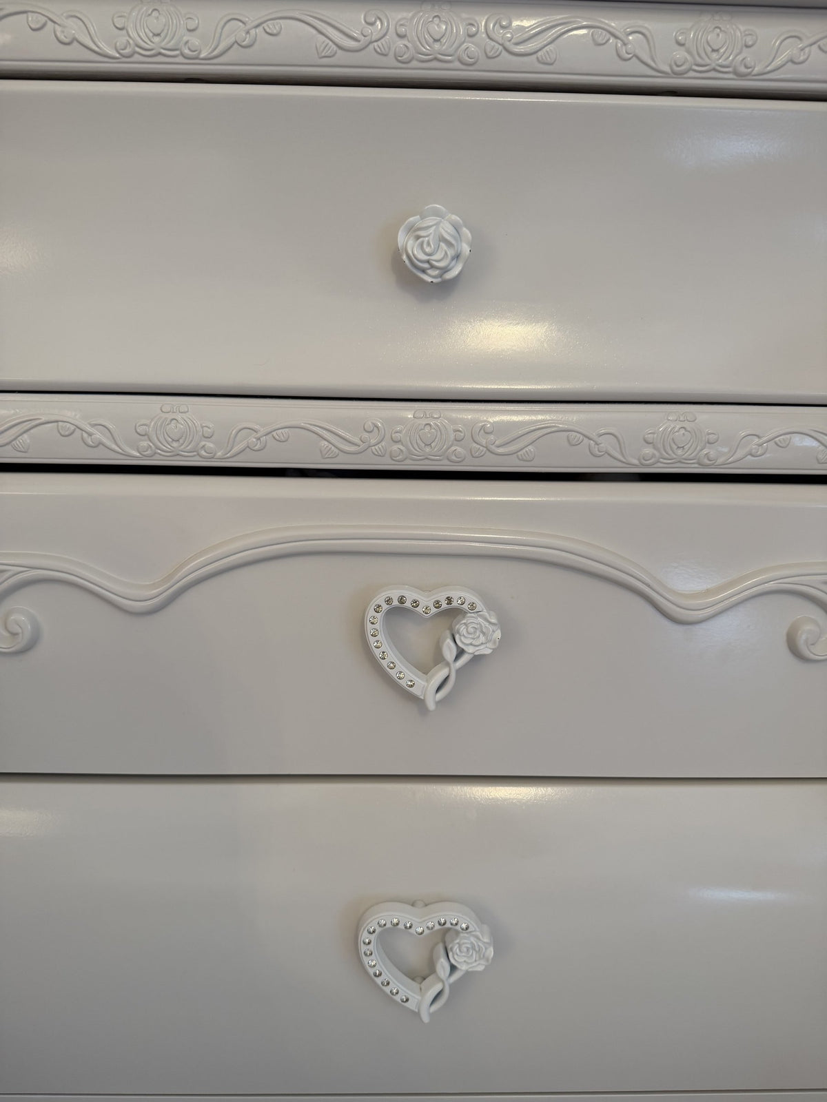 Heart and rose pulls and scroll appliqués on the chest drawers