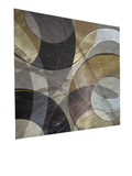 Angled view of a framed abstract canvas with overlapping circles in gray, black, and olive-gold tones hanging on a wall