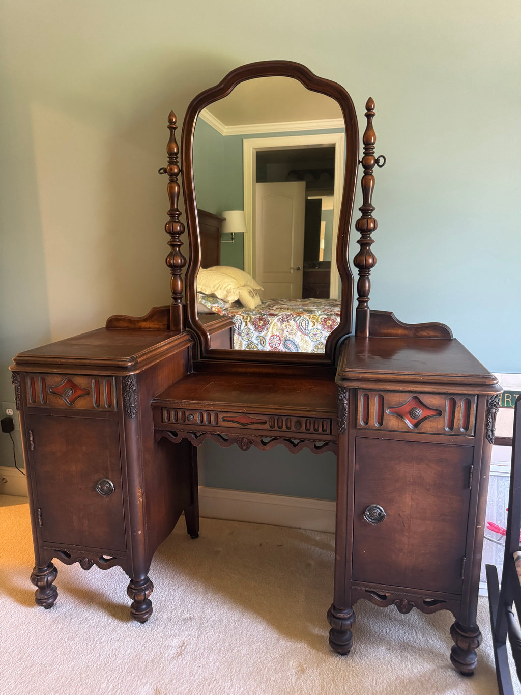 Full frontal view of vanity with centered mirror, symmetrical pedestals, and ornamental carved details