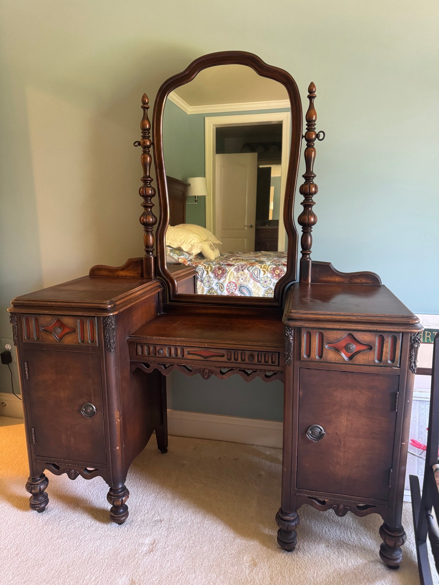 Full frontal view of vanity with centered mirror, symmetrical pedestals, and ornamental carved details