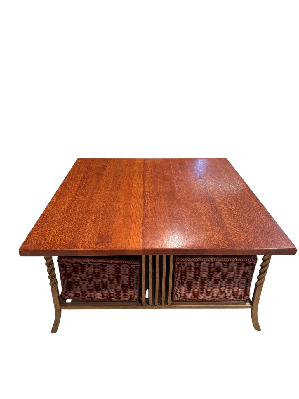 Quartersawn oak coffee table with wicker storage baskets, viewed from front, tan sofa and burgundy walls in background
