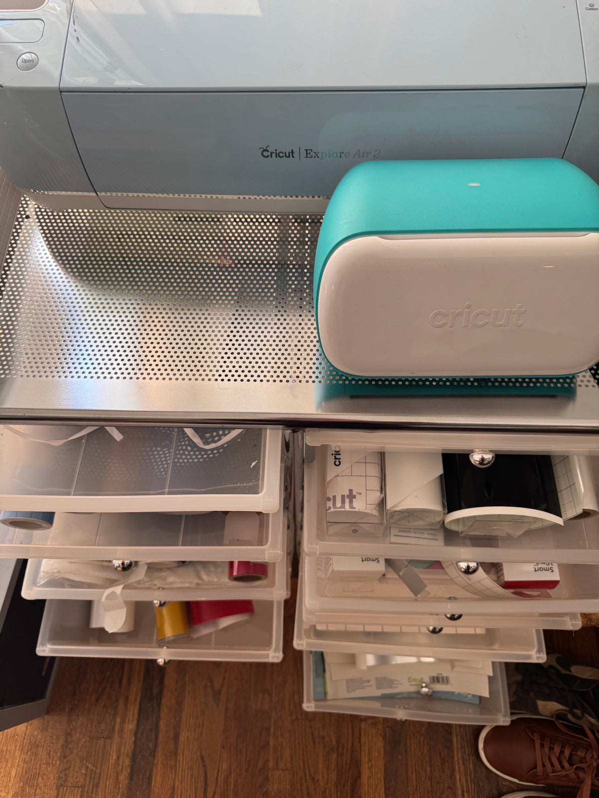 Cricut Joy compact cutting machine with teal top and cream base on work surface