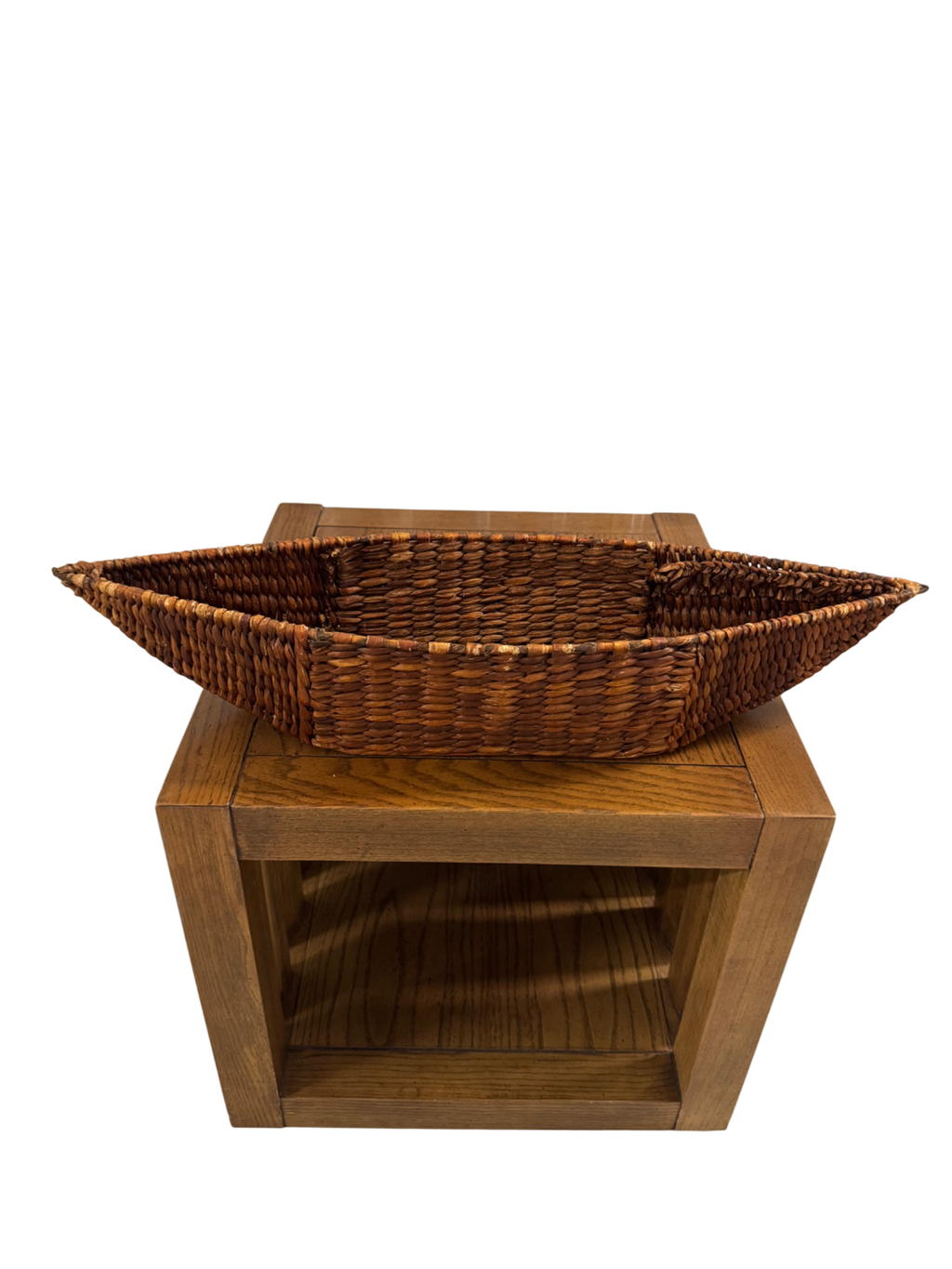 Wicker basket planter with pointed ends on wooden stand with open shelf, front view