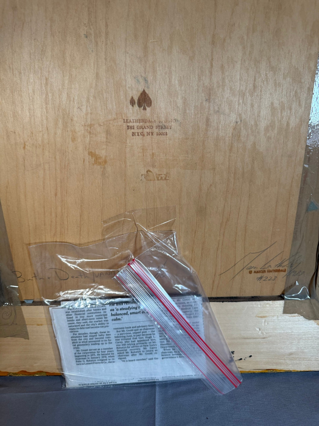 Back of the frame showing tape and a clipping