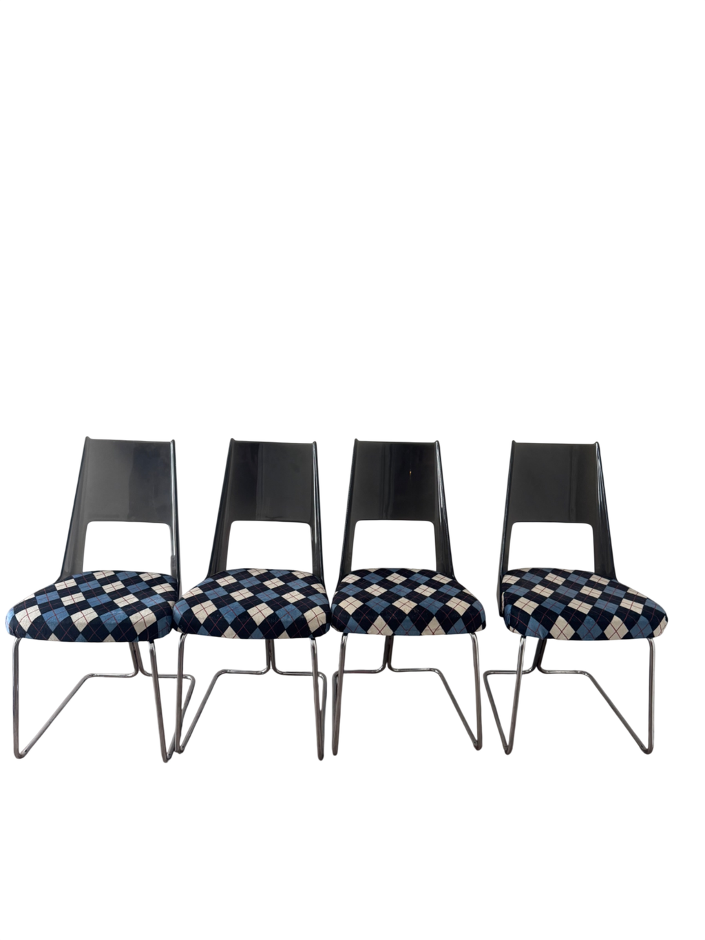 Four cantilever chairs displayed against white wall, metal chrome bases and black curved backs visible