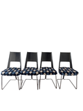 Four cantilever chairs displayed against white wall, metal chrome bases and black curved backs visible