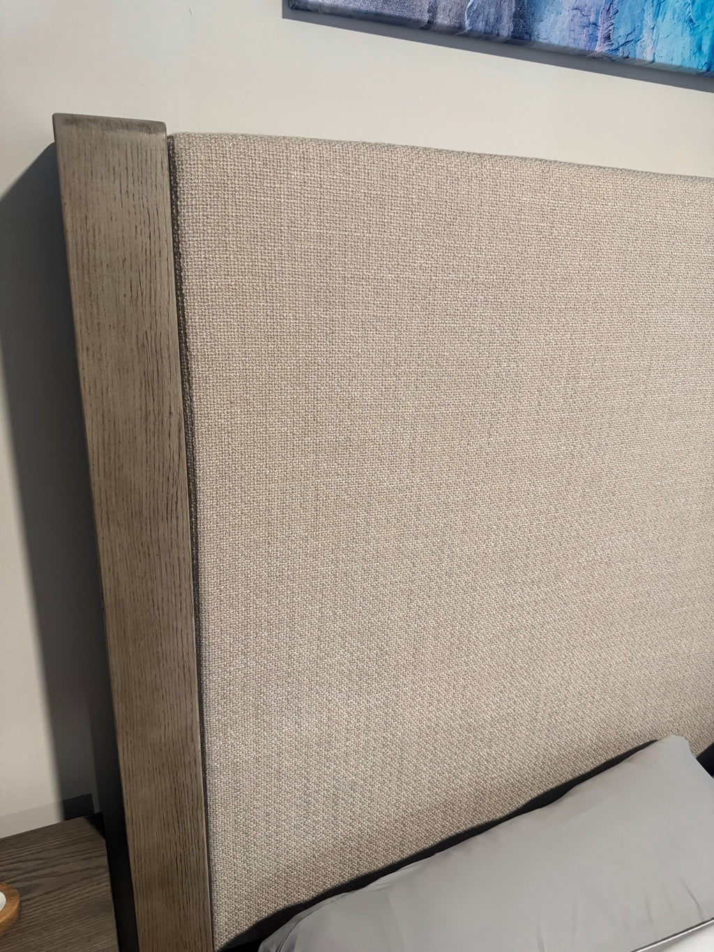 Oatmeal linen-look upholstered headboard framed in gray oak