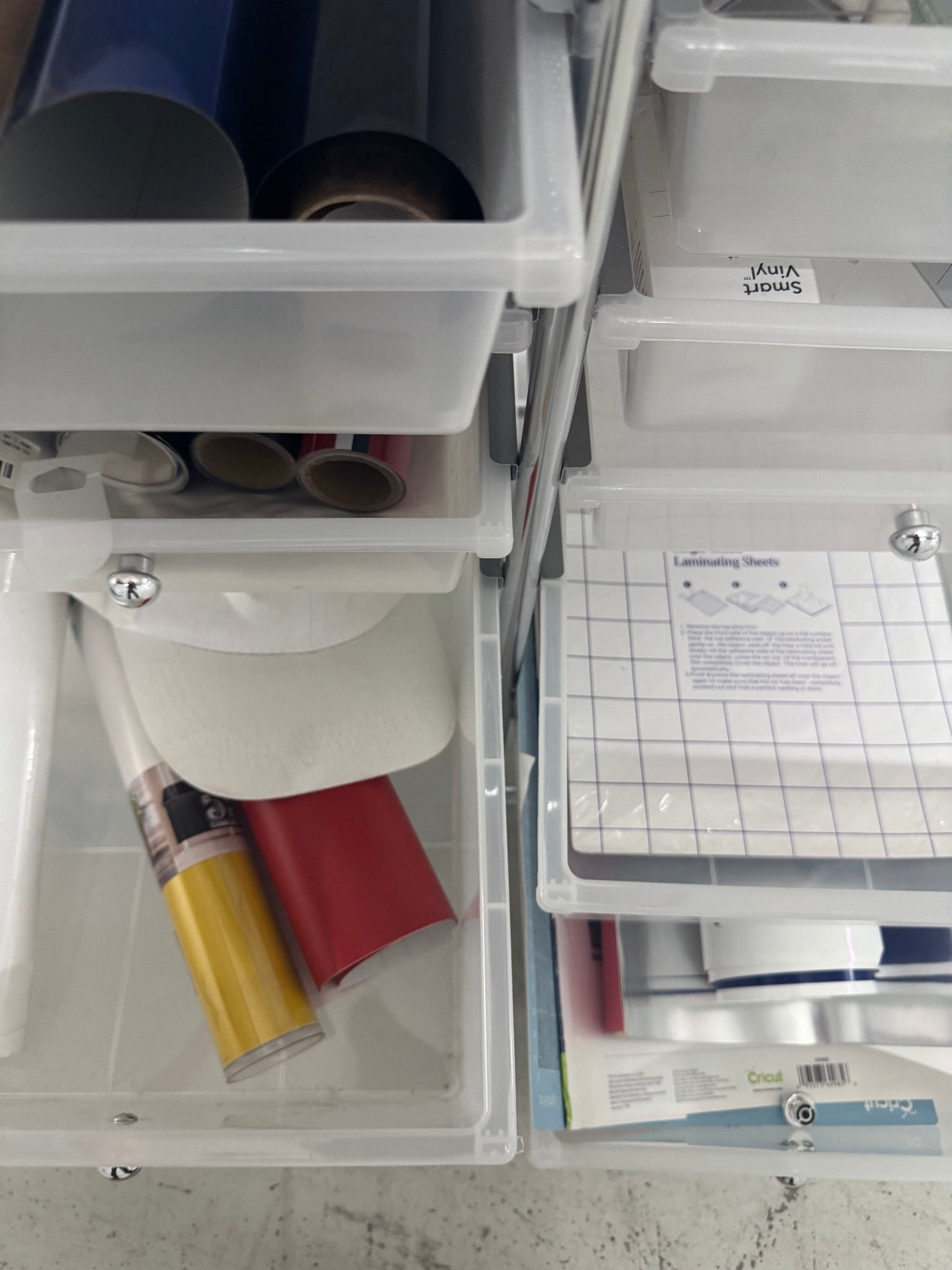 Lower drawer containing spray adhesive, paint can, and laminating sheets with instruction manual