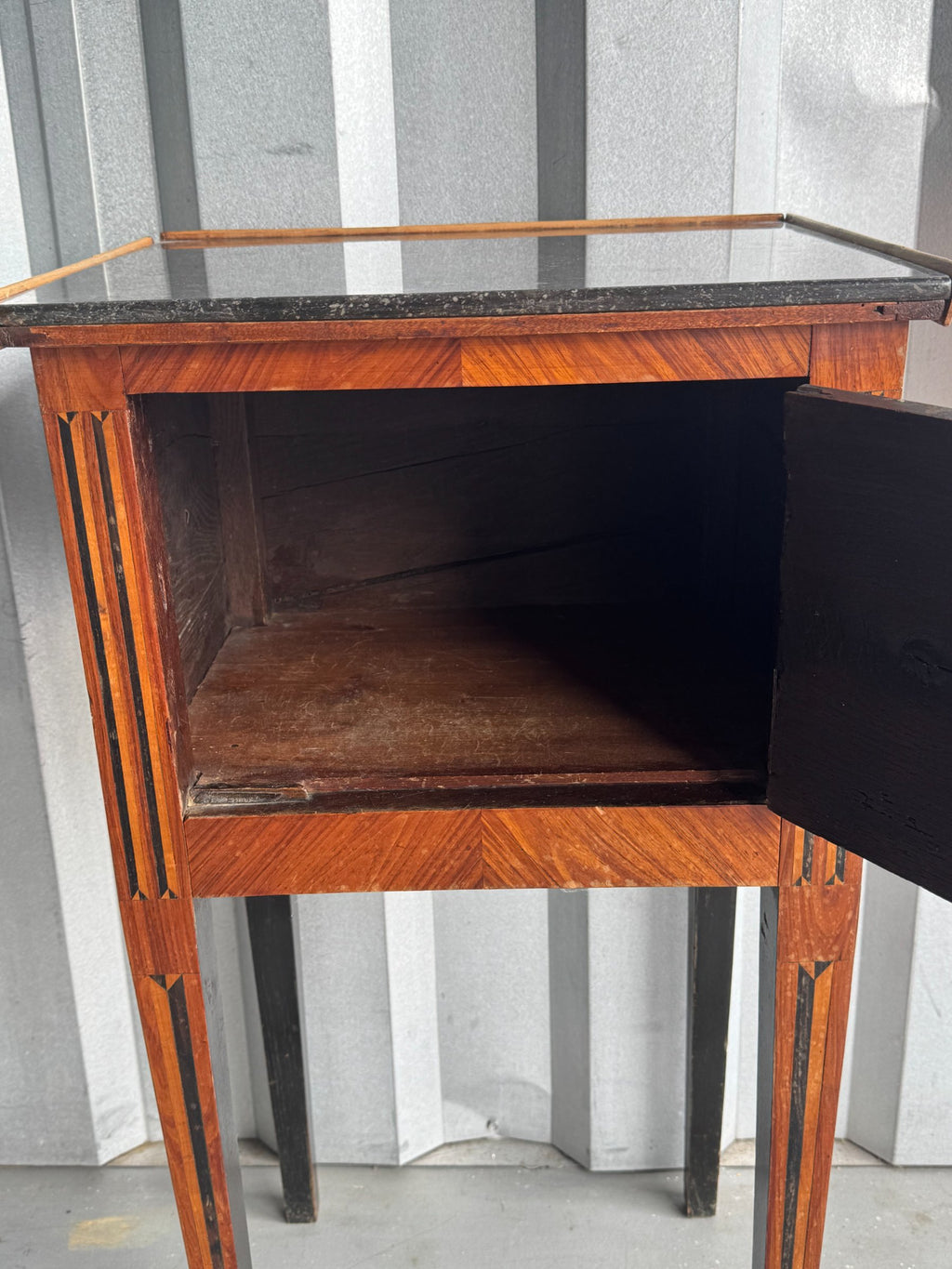 Interior of open drawer revealing dark wooden compartment, viewed from front angle