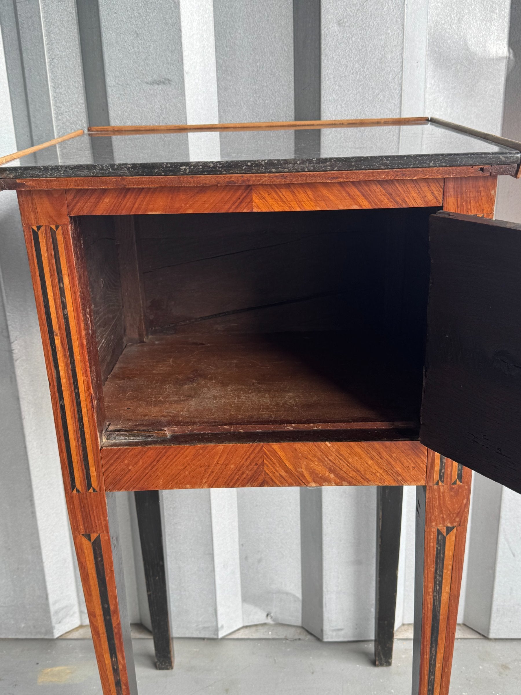 Interior of open drawer revealing dark wooden compartment, viewed from front angle