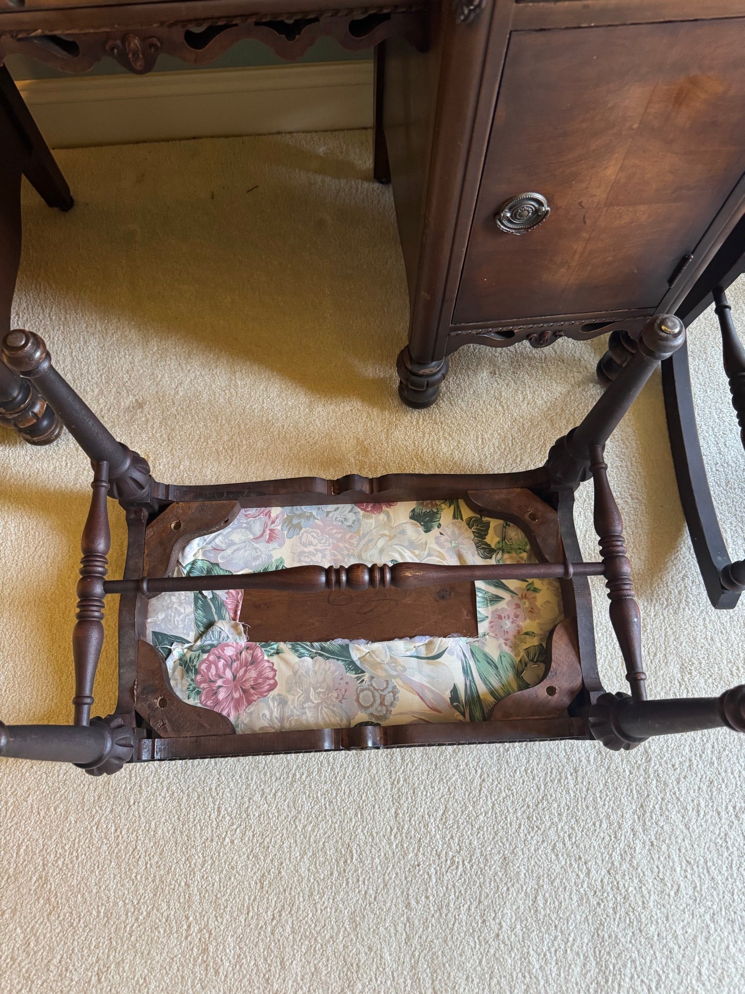 Underside of bench seat showing webbing support system and floral patterned upholstery attachment