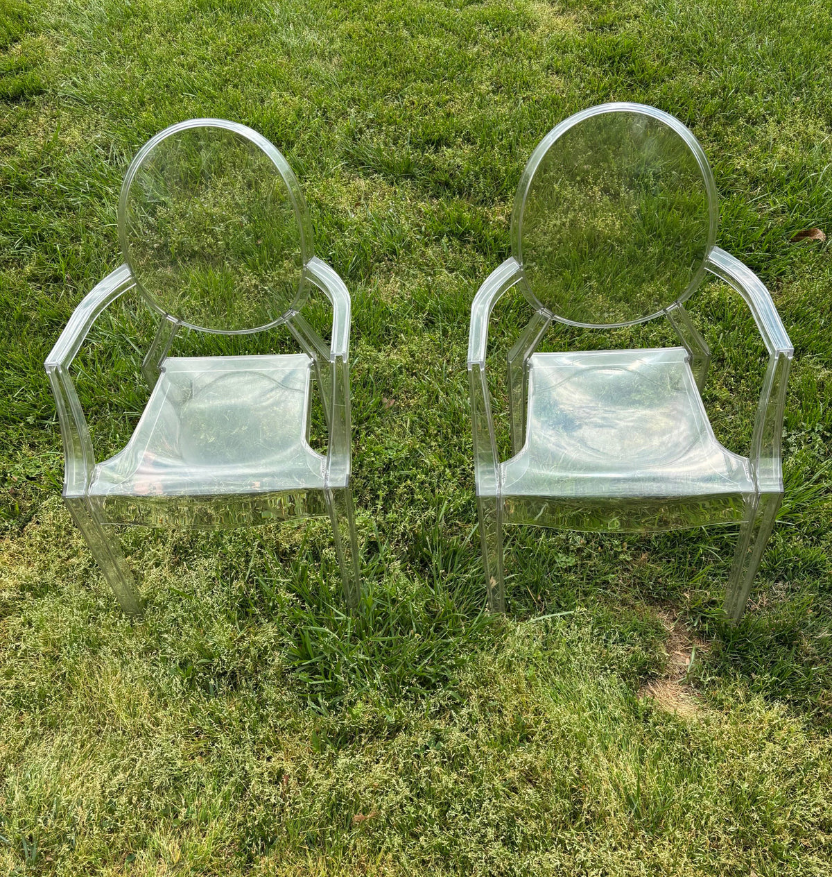 Two clear armchairs outdoors on grass