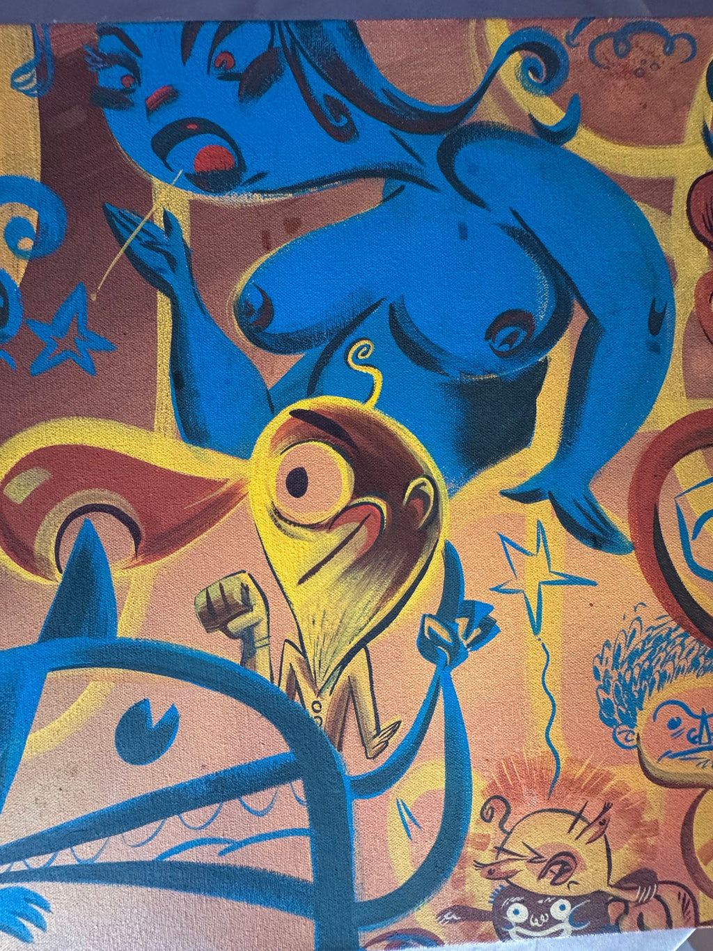 Detail of the blue creature and cartoon faces