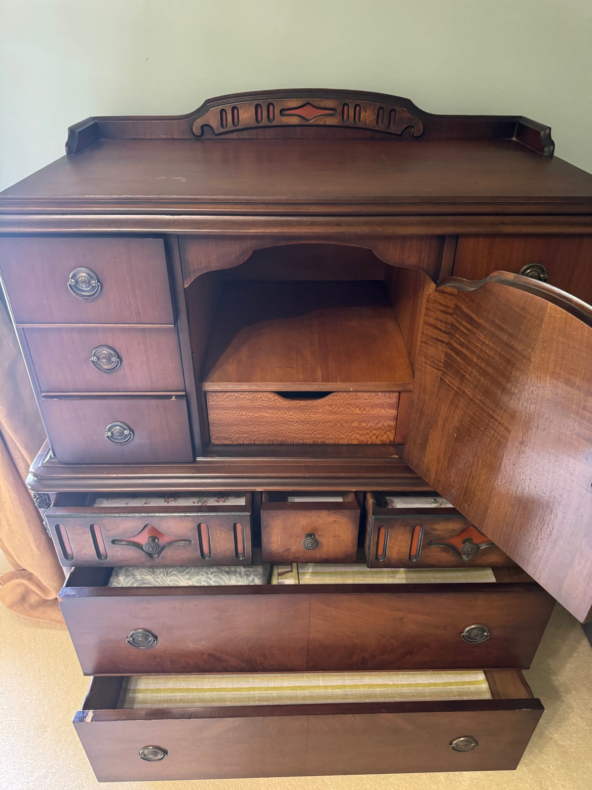 Interior detail of upper cabinet with open door, showing wooden shelf and interior storage compartment with drawer
