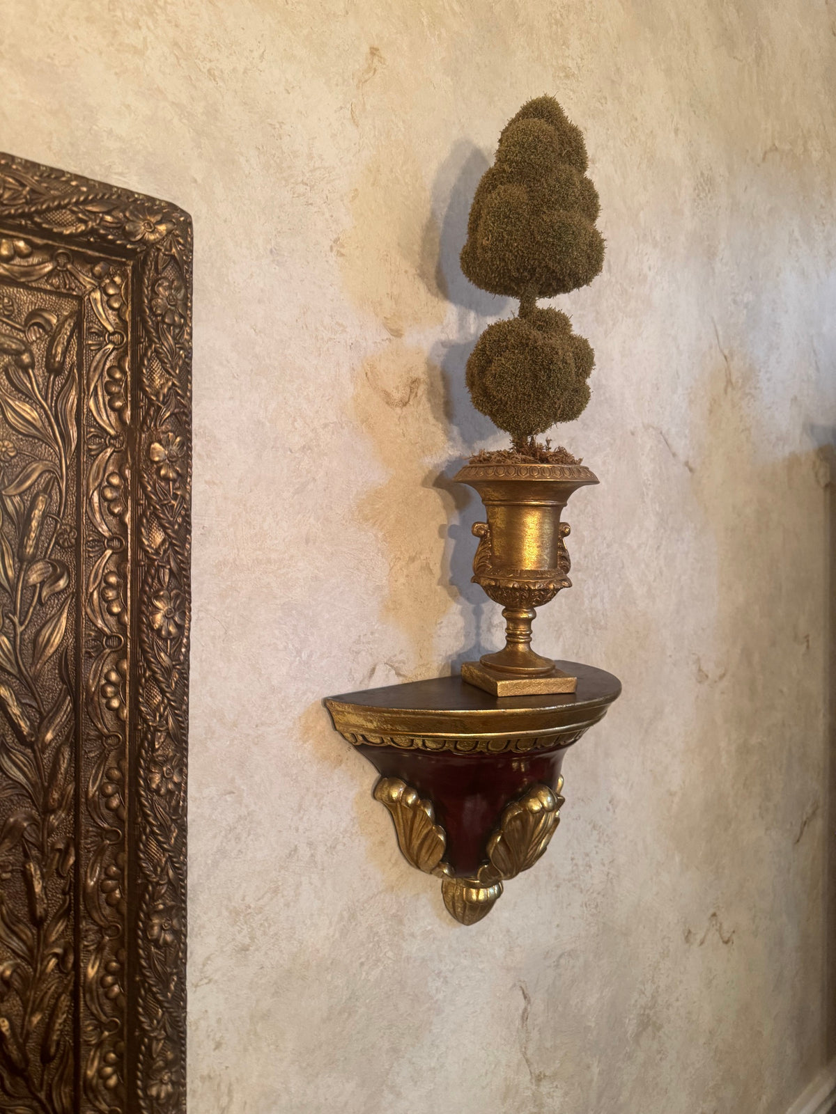 Side view of gilt urn topiary on scalloped wall bracket shelf with shell detail