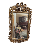 Ornate gilt wall mirror with scrolled frame