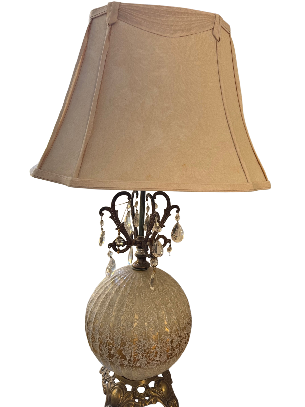 Table lamp with cream shade and frosted gold globe base on a glass-top table