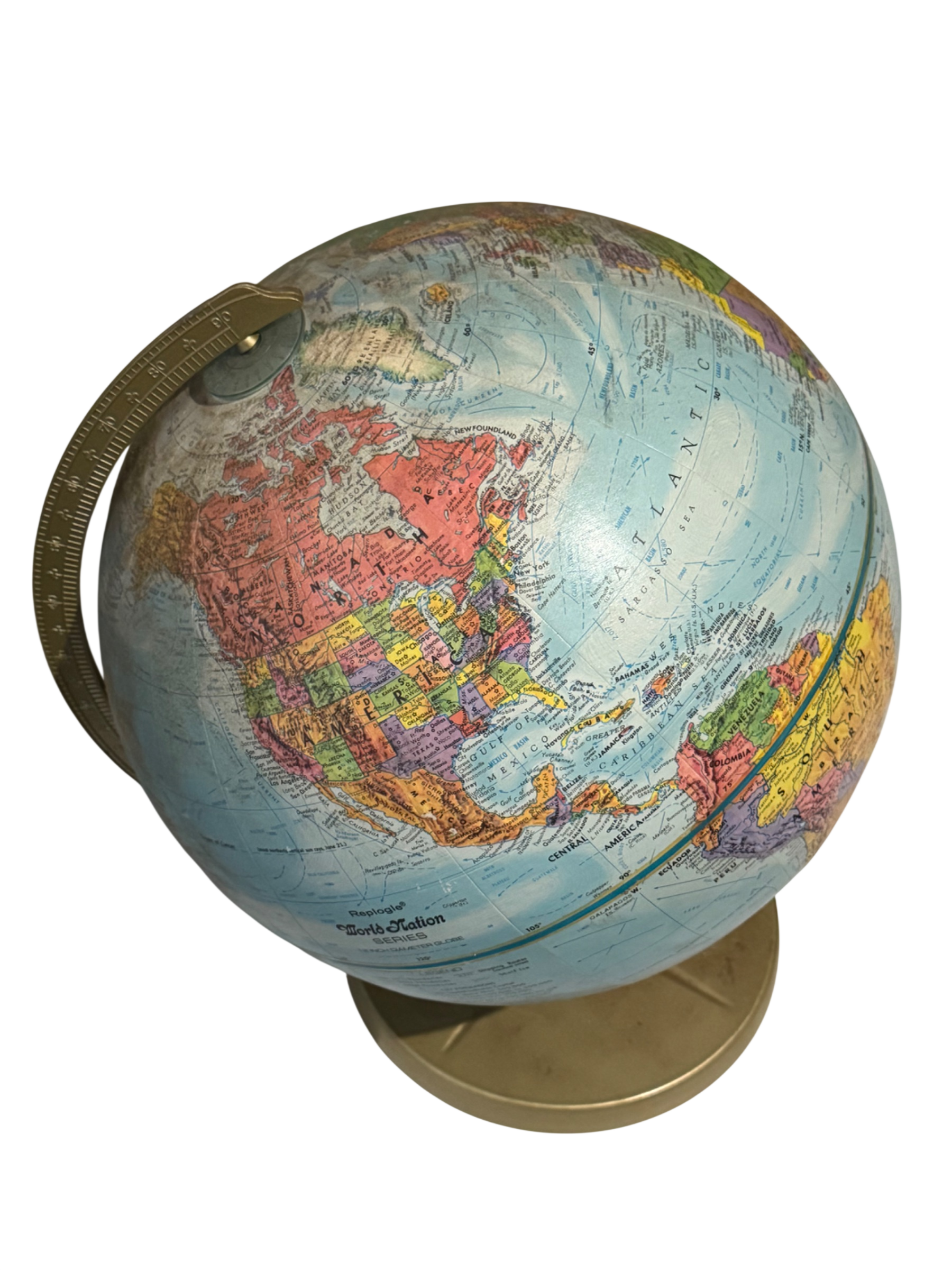 Vintage world globe with light blue ocean, colorful continent sections, brass stand and handle, viewed from front angle