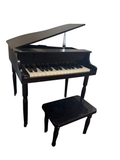 Black toy baby grand piano with bench on a fur rug