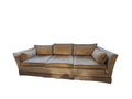 Gold velvet three-cushion sofa seen from the front in a bright room