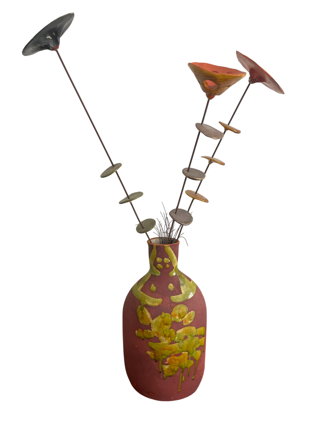 Handmade ceramic vase with pink and yellow glazed decoration, metal stems with various colored leaf and flower elements arranged in ikebana style