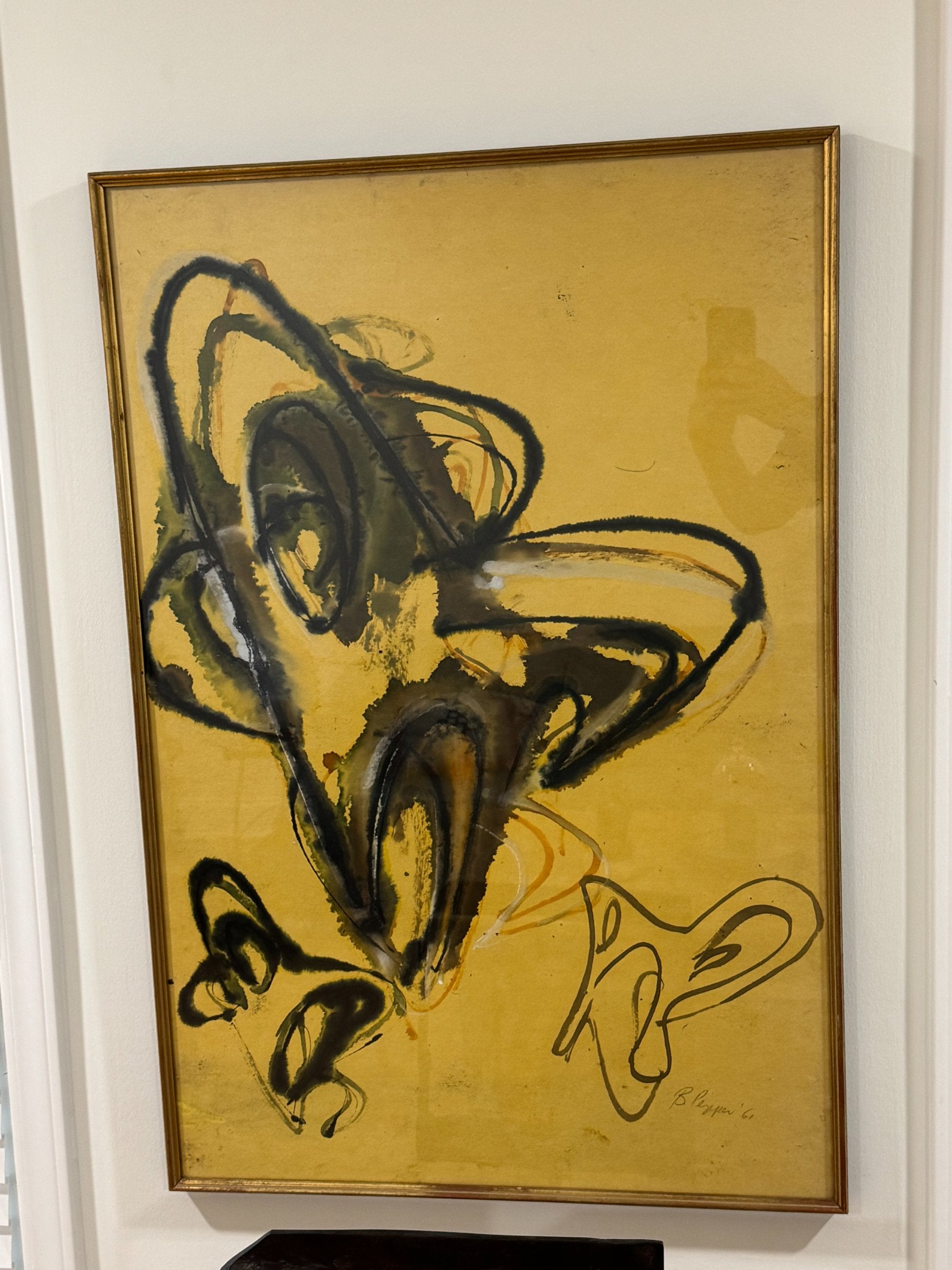 Complete framed artwork on wall with gold frame, abstract ink painting with dynamic sweeping lines and yellow ground