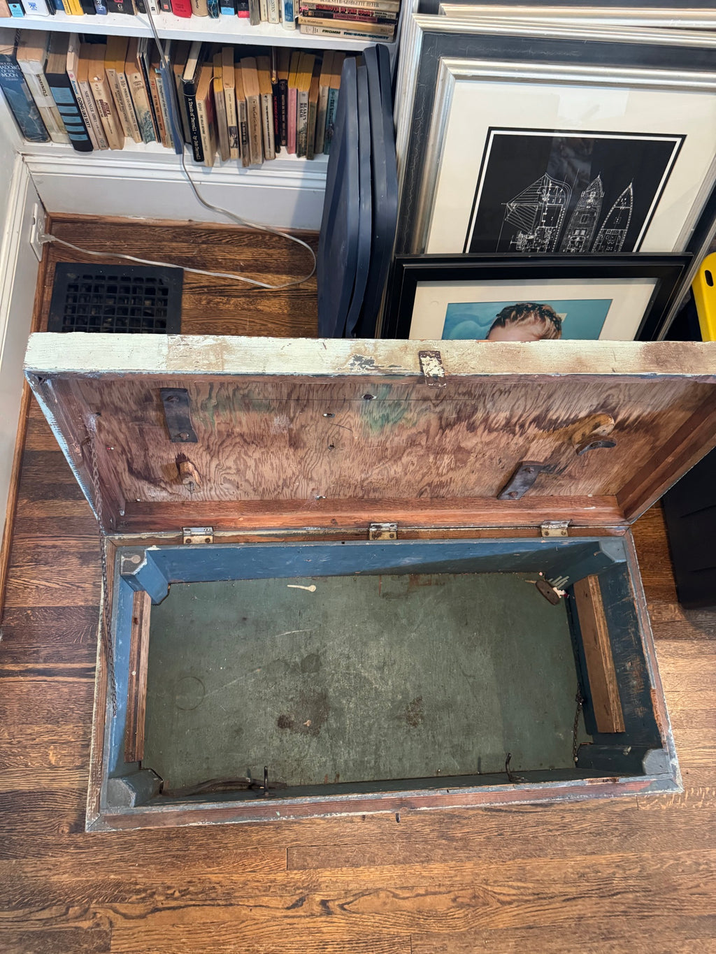 Open trunk from above angle displaying interior with dark wood lid and deteriorated green canvas bottom lining