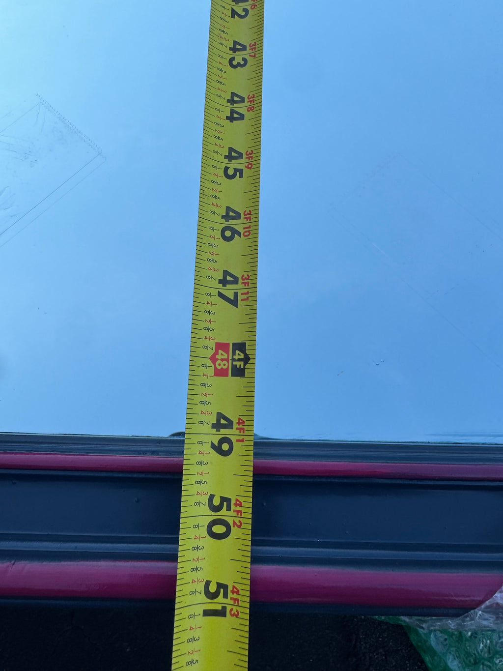 Tape measure showing approximately 51 inches width across the pink drawer fronts of the credenza