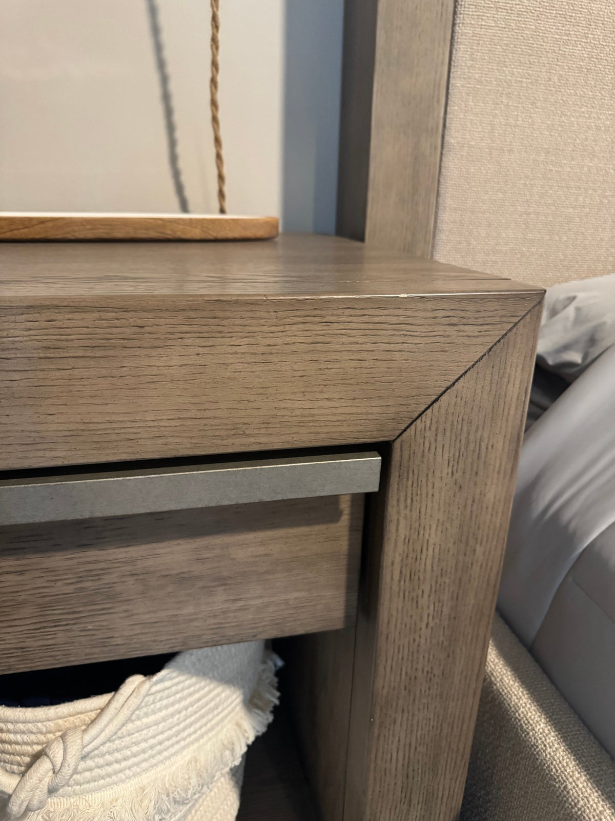 Corner detail of the gray oak nightstand and drawer pull