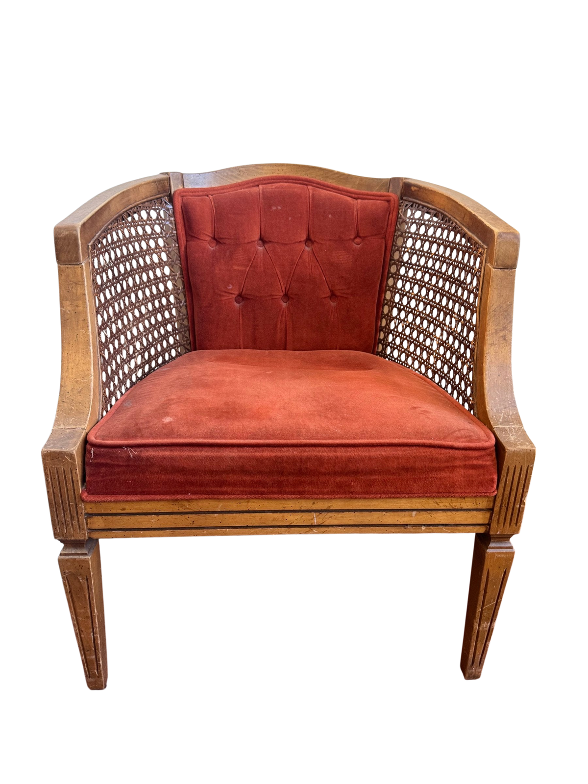 Cane-back barrel chair with rust velvet back and seat seen from the front