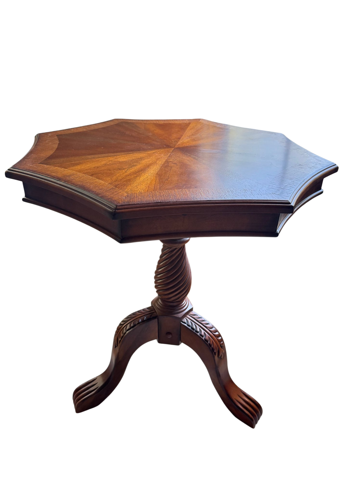 Octagonal wooden pedestal table with sunburst veneer top, carved tripod base with claw feet, viewed from above at angle