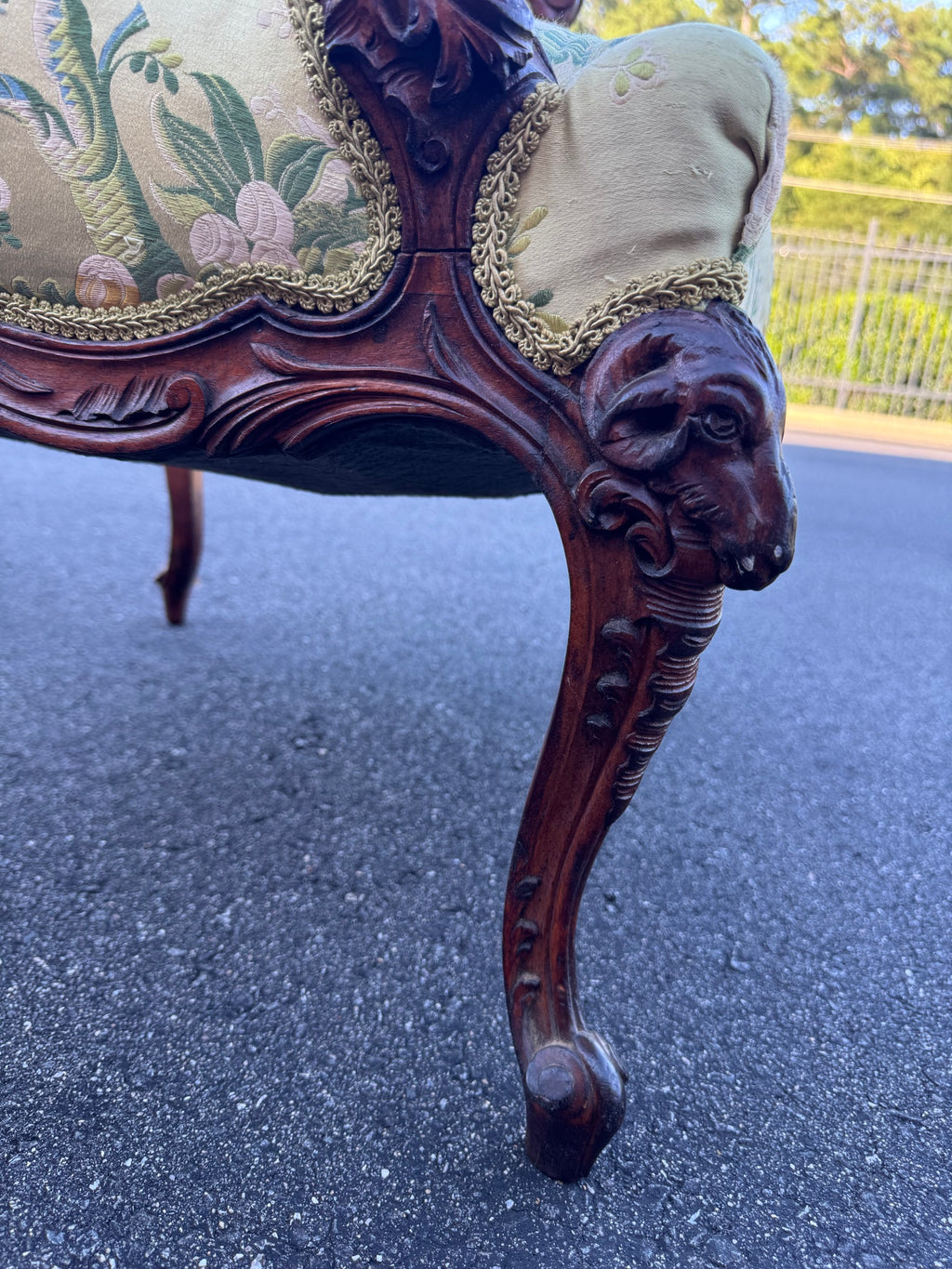 Full cabriole leg showing the ram's head at the knee and the fleece carved as a pendant trail running down to a scrolled toe